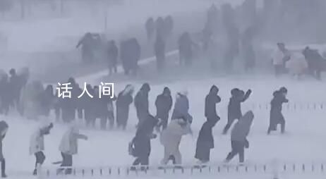 哈尔滨学生在暴风雪中艰难行走 街道路面犹如溜冰场